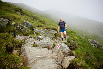 A middle-aged man walking on the mountain