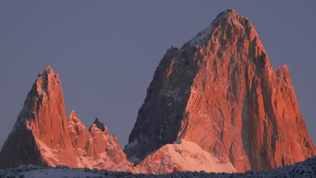 Orange-red morning light illuminates Mount Fitz Roy in Patagonia. Static zoomed-in view