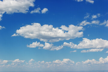 Fototapeta premium Stunning natural background with a clear blue sky filled with fluffy white cumulus clouds, creating a picturesque scene.