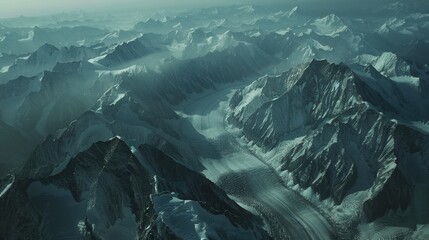 Obraz premium Aerial view of a snow-capped mountain range, glaciers carving paths, deep shadows emphasizing the peaks