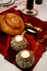 Shabbat table with two candles, bread and wine.