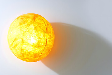 yellow light effect ball planted on white background, top view