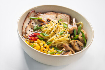Udon with chicken, mushrooms, corn, pepper in a white bowl