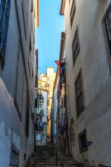 Fototapeta premium View of steep narrow Lisbon streets at medieval quarter Alfama