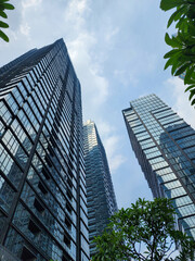 Low-angle view of a blue glas windwos skyscraper with a clear blue sky background. Business and finance concepts.