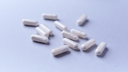 Tyrosine capsules (one of the 20 standard amino acids). A dietary supplement used to improve attention and focus on paper background. Soft focus. Close up.	