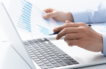 Financial data analysis of personal business. Manager reviewing reports with laptop.