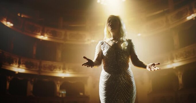 Talented Female Opera Performer Enchants the Audience With Her Powerful Voice and Dramatic Gestures. Delivering a Riveting Theater Performance on a Historic Grand Stage with Gold Interior Decor
