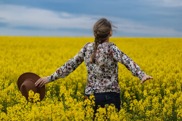 Kobieta w polu rzepaku zachwycająca się przyrodą © Ciupek