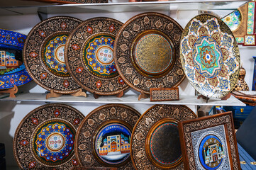 handmade Uzbek wooden souvenir plates with wood carvings hand-painted patterns in bazaar of Uzbekistan in Tashkent