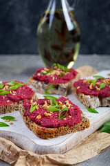 Toasts with beetroot, chopped nuts and herbs. Vegan bruschetta with beet