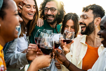 Happy friends toasting red wine glasses outside - Group of young people having bbq dinner party in backyard house - Winery and bbq dining concept with guys and girls cheering alcohol together