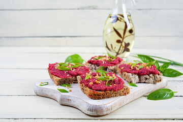 Toasts with beetroot, chopped nuts and herbs. Vegan bruschetta with beet