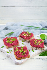 Toasts with beetroot, chopped nuts and herbs. Vegan bruschetta with beet