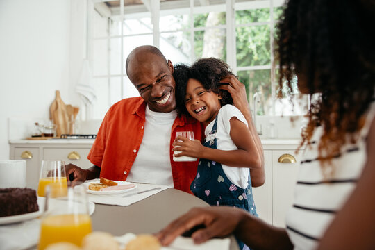 Family moment - Father hugging daughter at breakfast
