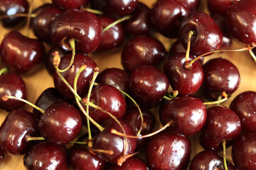 Cherries on the table, close-up. Wet sweet ripe cherries. Dark red cherries with green stems covered with fine splashes of water. Summer berries, vitamins. Washed cherries