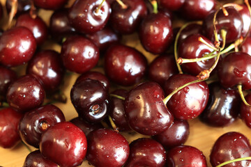 Cherries on the table, close-up. Wet sweet ripe cherries. Dark red cherries with green stems covered with fine splashes of water. Summer berries, vitamins. Washed cherries