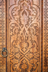 traditional Arabic Uzbek Islamic patterns arabesque ornament on an modern wooden carved door in Uzbekistan close-up
