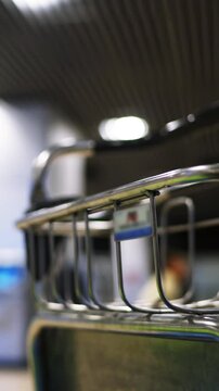 4k ultra hd. Emty airport luggage cart standing in departure or arrival zone with blurred people at the background waiting for their gate opening. Metal and plastic tripod shot. Time waste concept