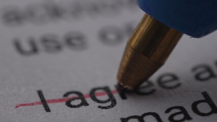 Pen Crossing Out 'I Agree' on Document. Extremely Close-up, shallow dof.