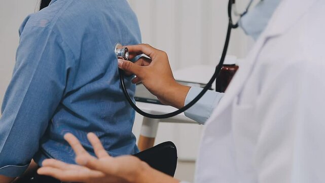 Doctor use stethoscope, checking up heart beat, lunch of auscultation in doctor office at hospital. Patient worker has to get medical checkup every year for her health or medical checkup cardiologist