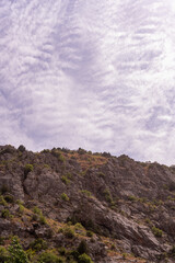 A mountain with a cloudy sky in the background