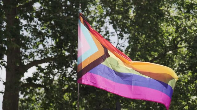 Pride progress flag being carried waving at LGBT parade in the United Kingdom
