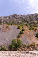 A mountain with a rocky hillside and a river running through it