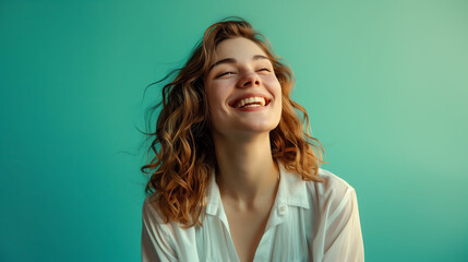 Fototapeta premium A joyful millennial woman in white, confidently smiling against a solid turquoise background