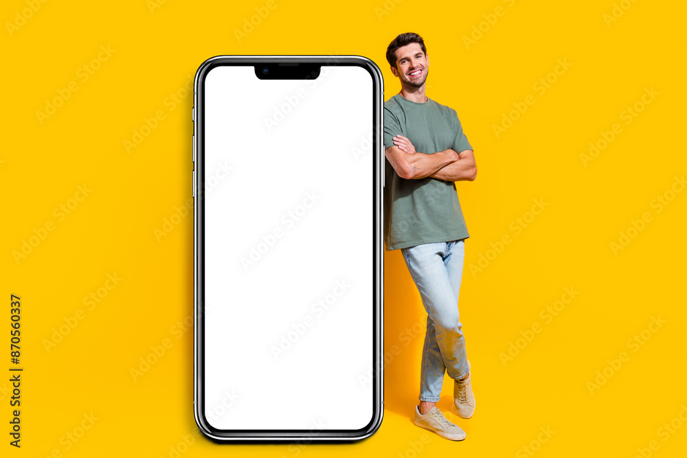 Poster full length photo of positive confident man dressed khaki t-shirt positing modern gadget empty space