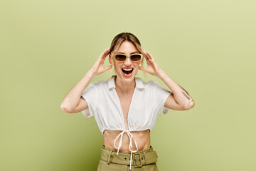 A young woman with vitiligo is posing in a white summer outfit against a green background.