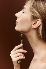 A young woman with vitiligo uses a jade beauty tool on her neck in a skincare ritual.