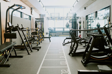 Spacious workout zone in premium fitness club, zone equipped with different types of exercise machines and boxing bag