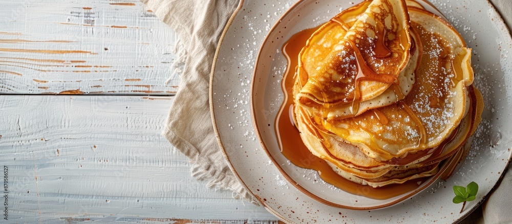 Poster close-up of delicious homemade caramel stuffed pancakes on a white wooden background with selective 