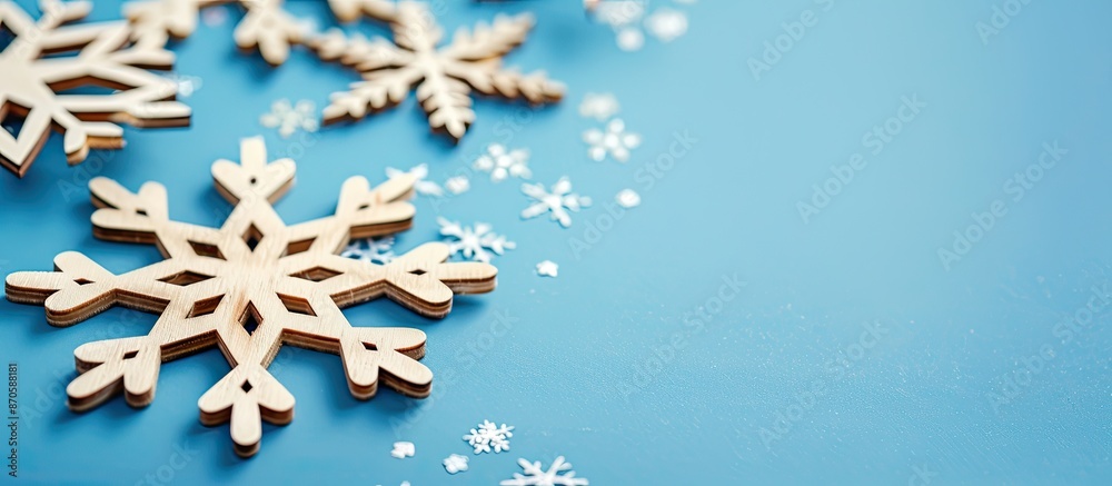 Poster close-up view of decorative wooden christmas snowflakes on a blue background, creating a festive new