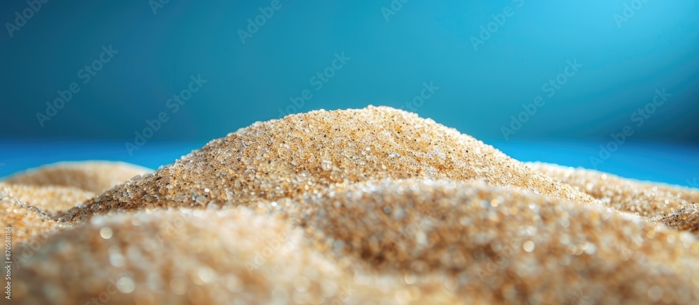Poster close-up of a pile of sand with a blue background, featuring ample copy space image.