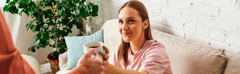 A woman with a prosthetic leg accepts a cup of coffee from her boyfriend, smiling warmly at him.