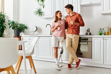A woman with a prosthetic leg and her boyfriend enjoy a casual moment together in their kitchen.