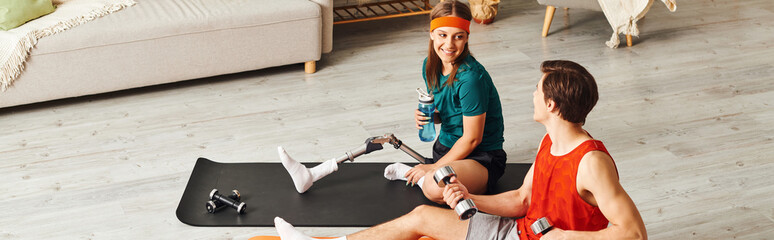 A woman with a prosthetic leg and her boyfriend workout together at home.