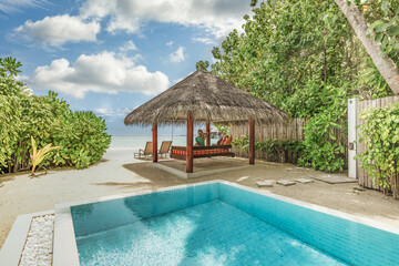 Interior and exterior design of luxury pool villa beautiful poolside and sunny sky. Luxurious tropical beach vacation landscape couple.  Beautiful spa or wellness concept, recreational vacation resort