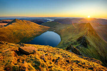 Golden sunrise from Helvellyn in The Lake District, overlooking Striding Edge and Ullswater.