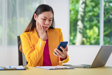 Fototapeta premium An Asian businesswoman is diligently working at an accountant's desk, surrounded by financial documents and a laptop, meticulously analyzing data to ensure accurate and efficient financial management.