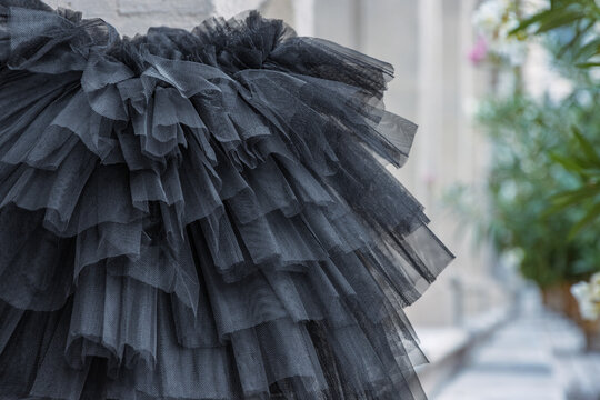 Black layered tutu laying on the stone stairs. Tulle ballerina skirt. Multilayered black skirt. Closeup. Selective focus