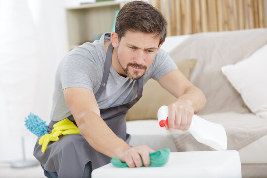 a man cleaning wooden table