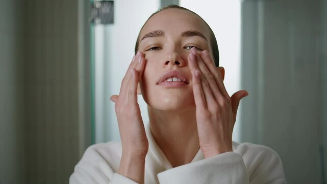 Beauty girl massaging serum on face closeup. Attractive woman applying cream