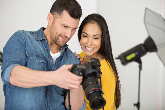 photographer and model reviewing photos on camera screen