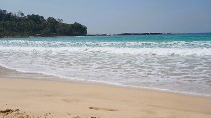 Waves on the beach, beautiful beach view, white sand with clear blue sky  at Sawarna Beach, Banten