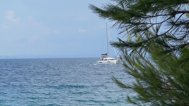 Boat with a sail on the birch water of the Adriatic sea. A white sailboat sails on the blue sea. Sailing holidays off the coast of Croatia, Preko island, June 27, 2024