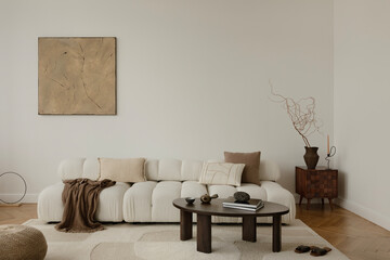 .A serene, minimalist living room with a plush, white sofa adorned with neutral cushions and a cozy...