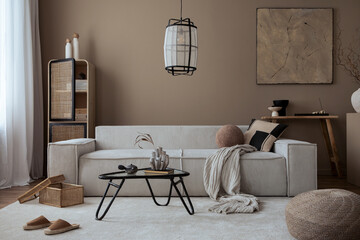 Interior design of living room with mock up poster frame, beige sofa, glass coffee table, beige wall, pouf, rattan sideboard, slippers, wooden bench and personal accessories. Home decor. Template.